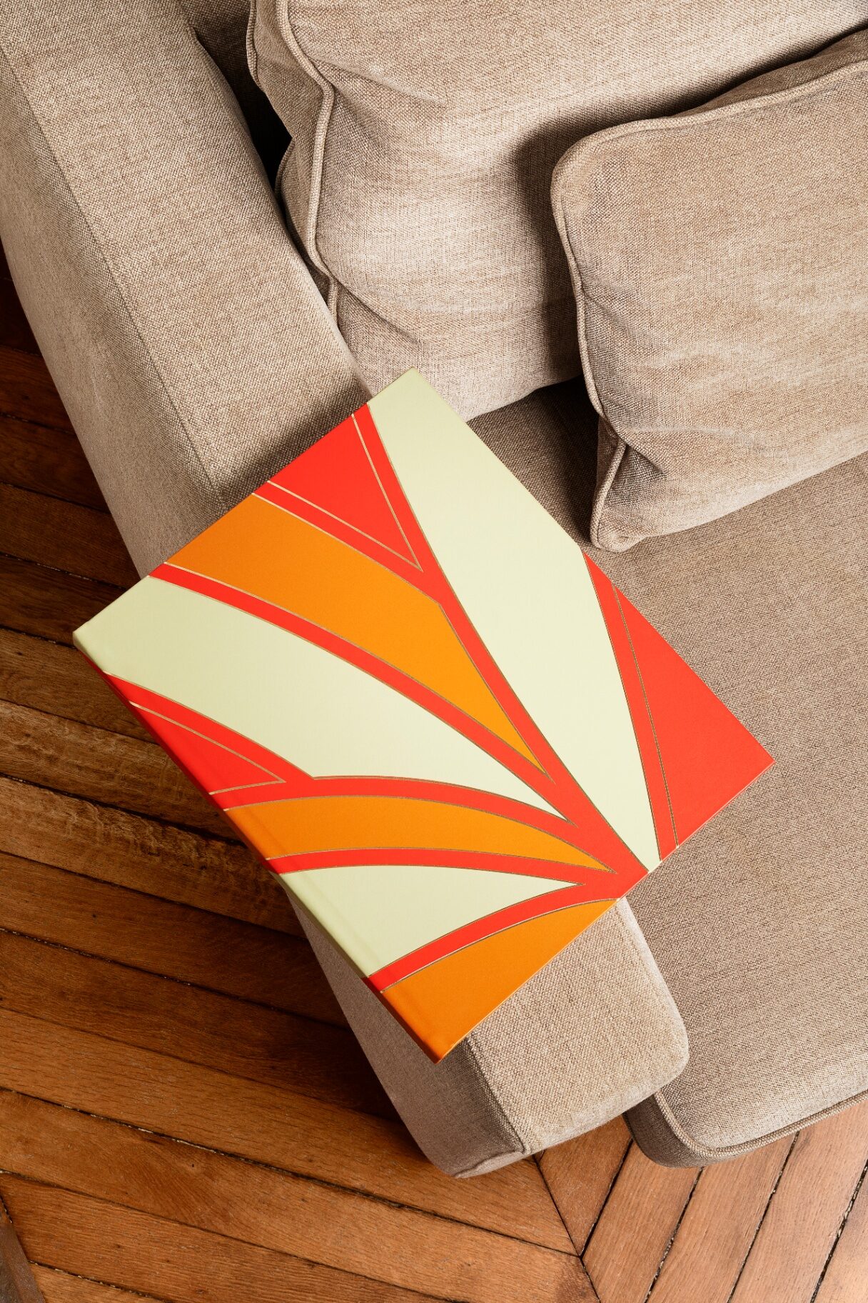 Coffret Belfeuil aux motifs Art déco rouge et orange posé sur un canapé